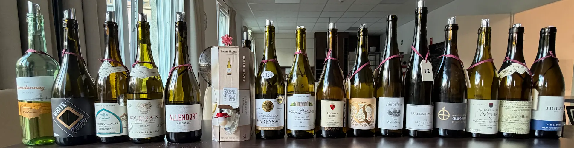 Reihe verschiedener Chardonnay-Weinflaschen auf einem Tisch
