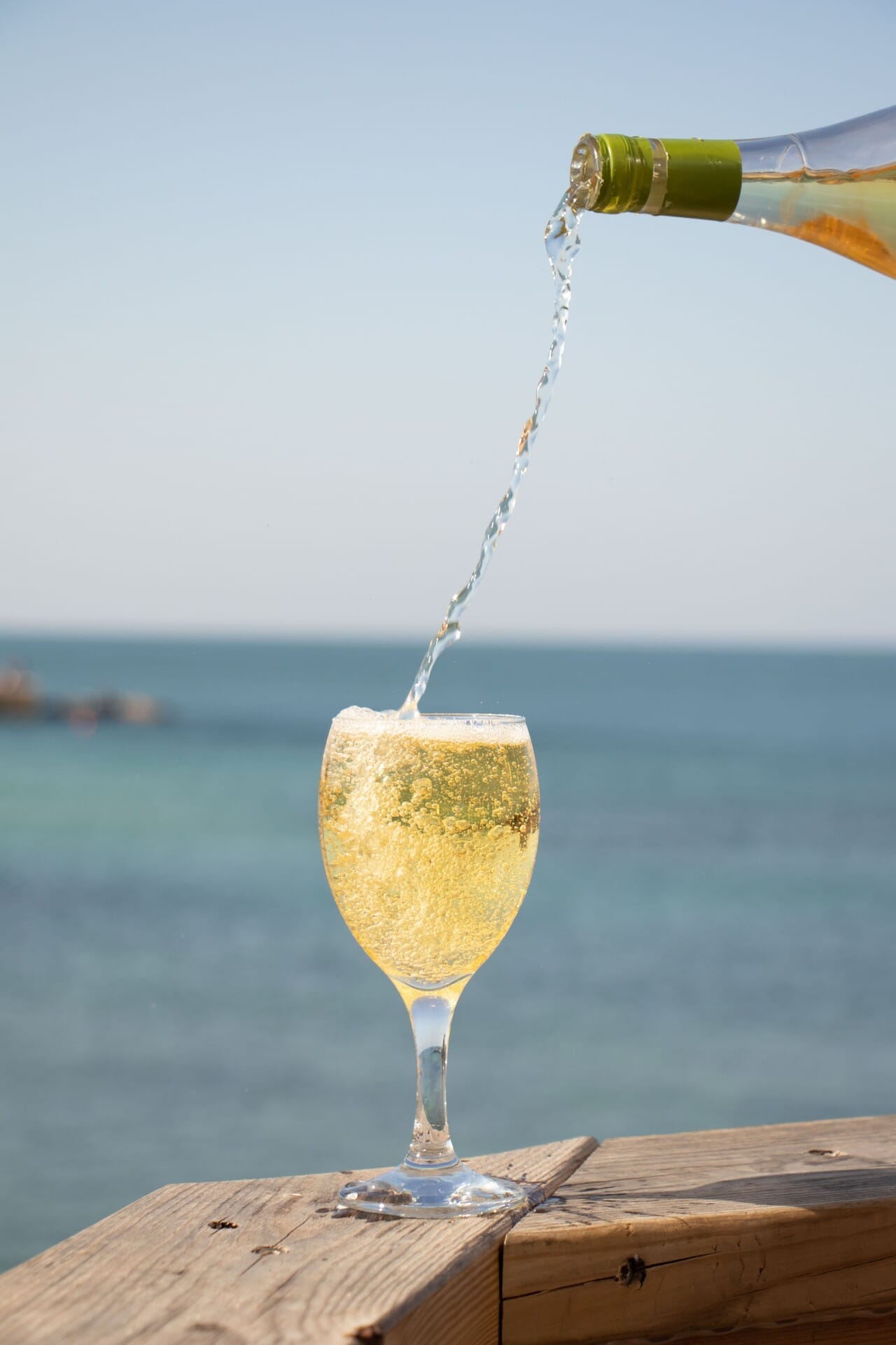 Weißwein eingegossen am Meer